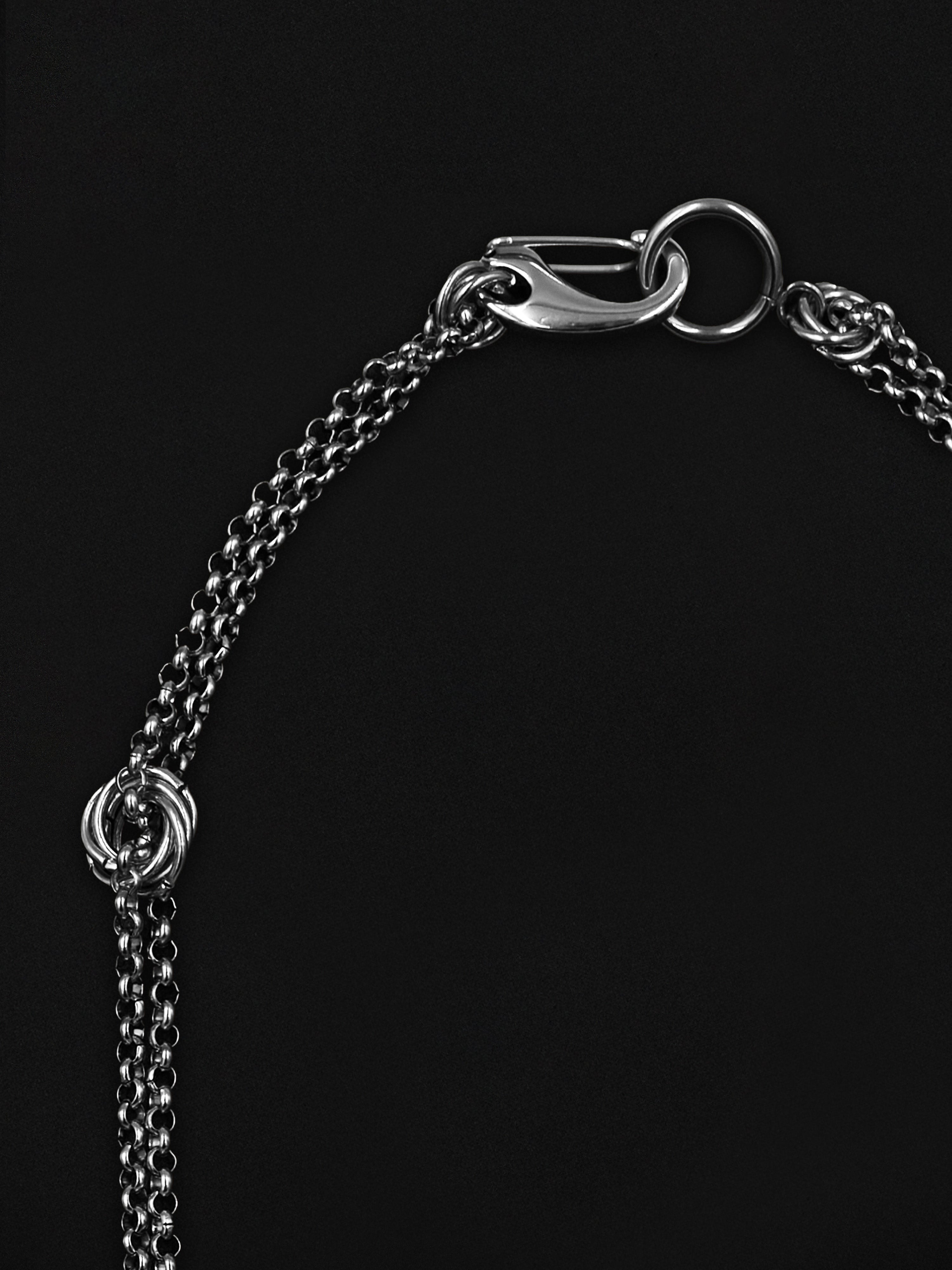 Close-up of a silver chain necklace on a black background