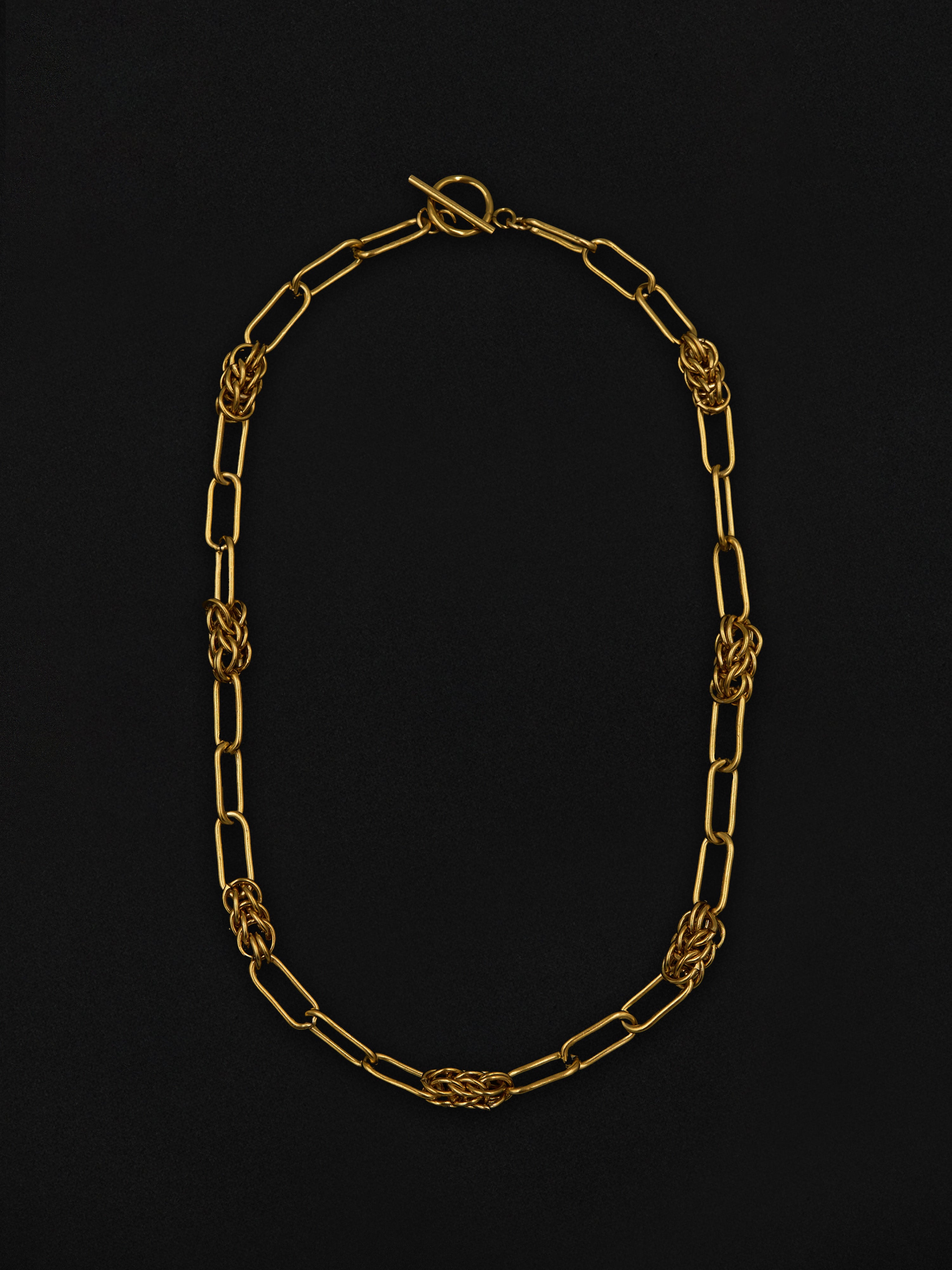 Gold chain necklace on a black background