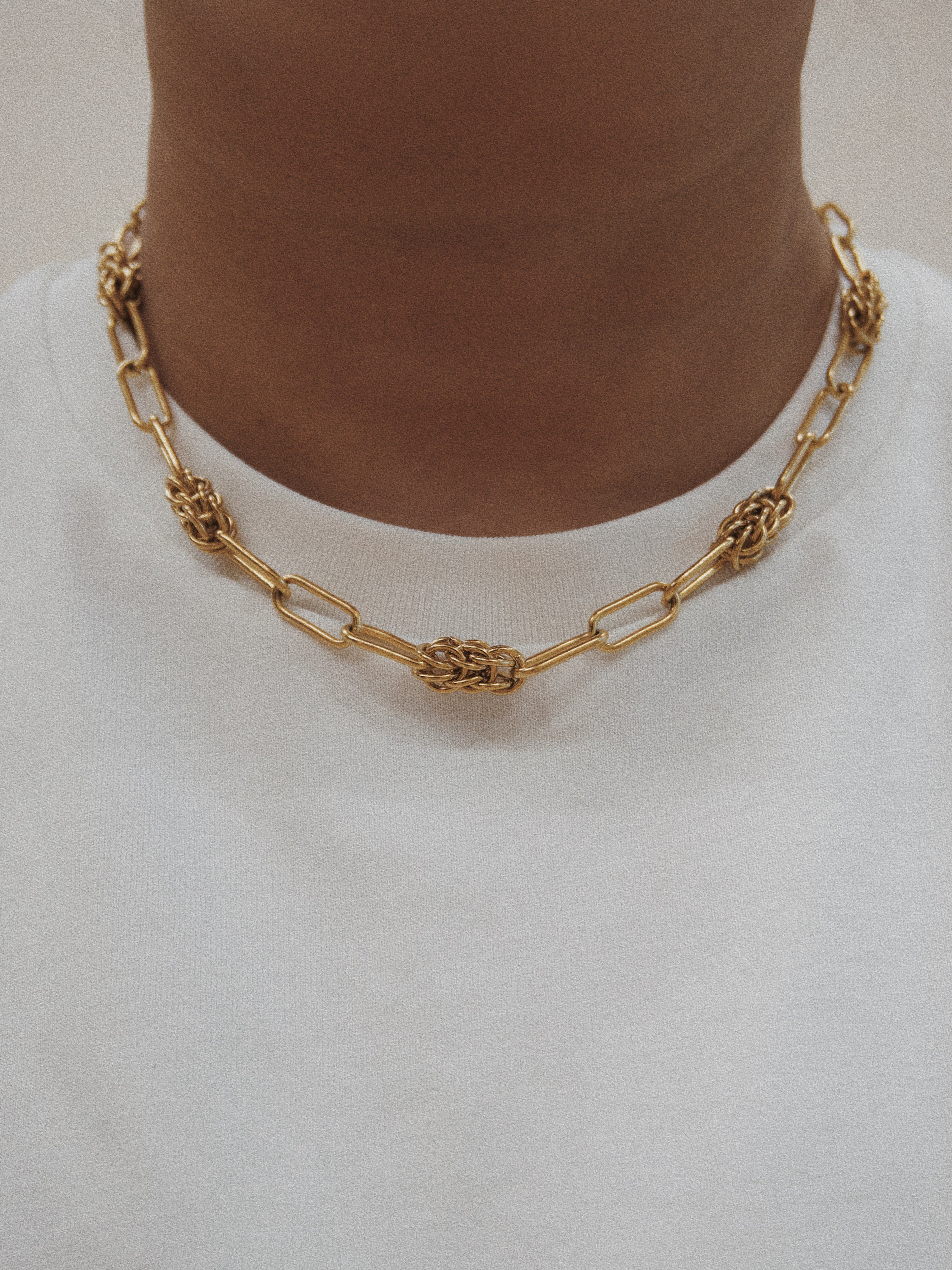 Gold chain necklace on a plain background