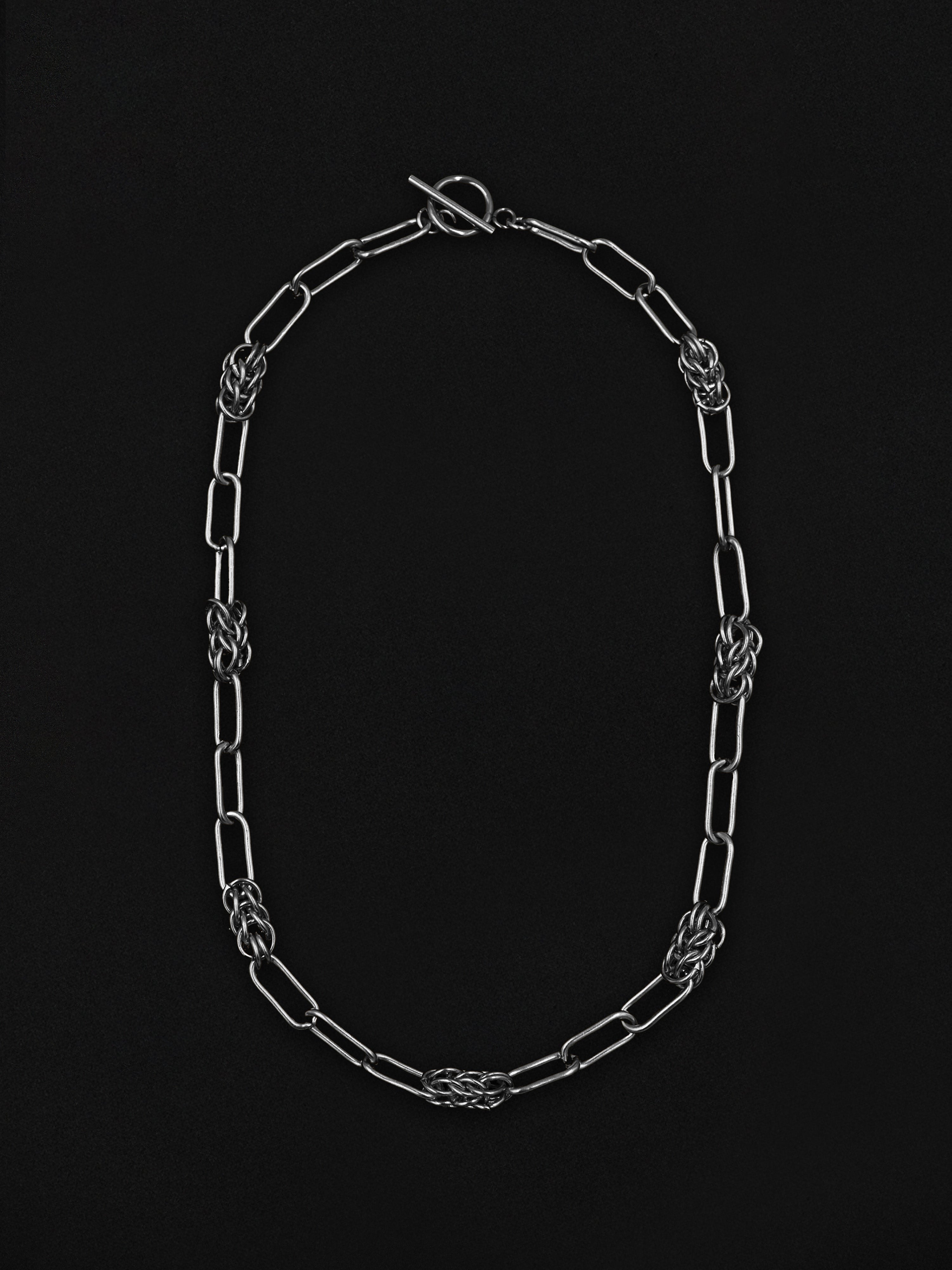 Silver chain necklace on a black background