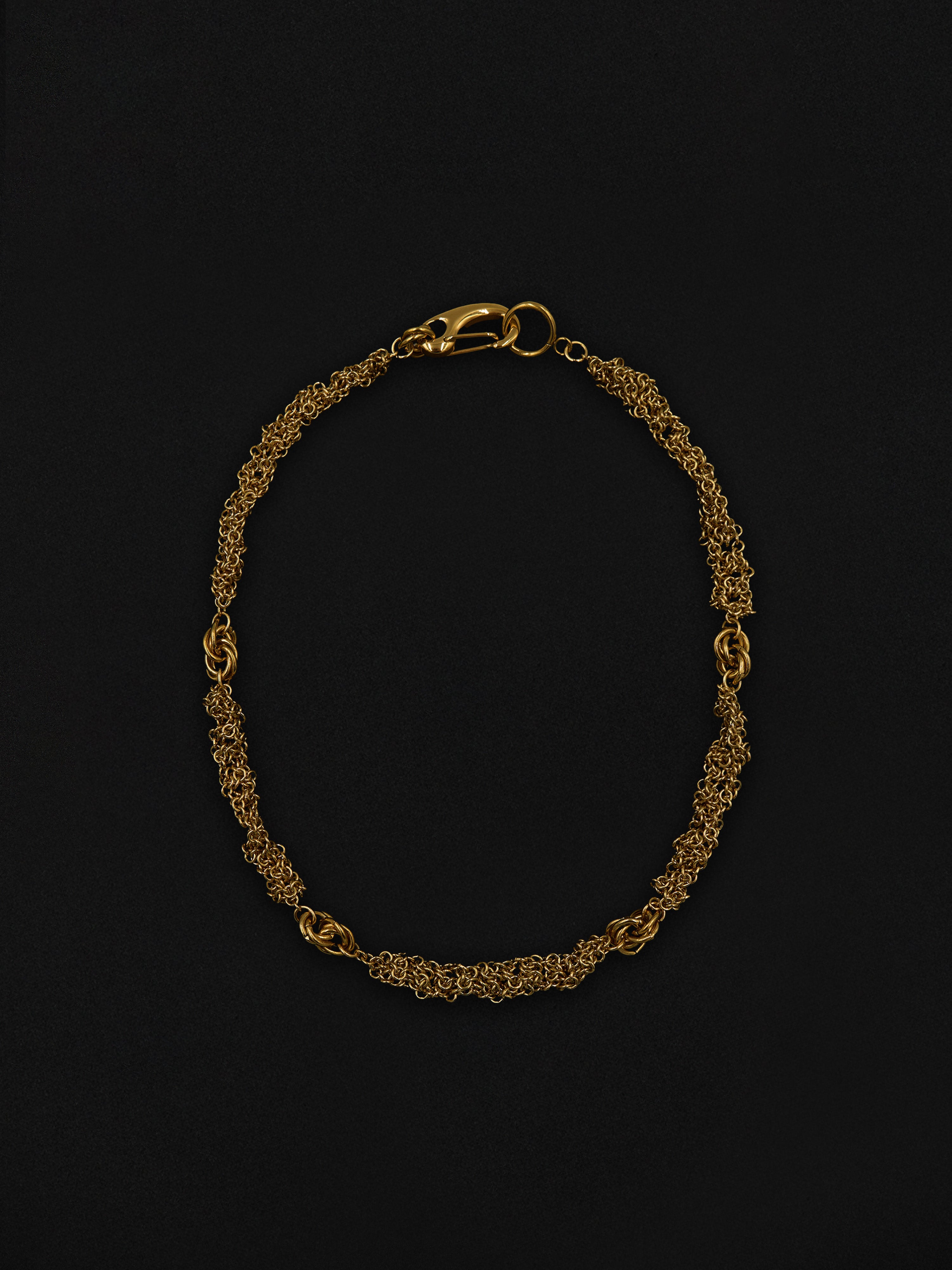 Gold chain necklace on a black background