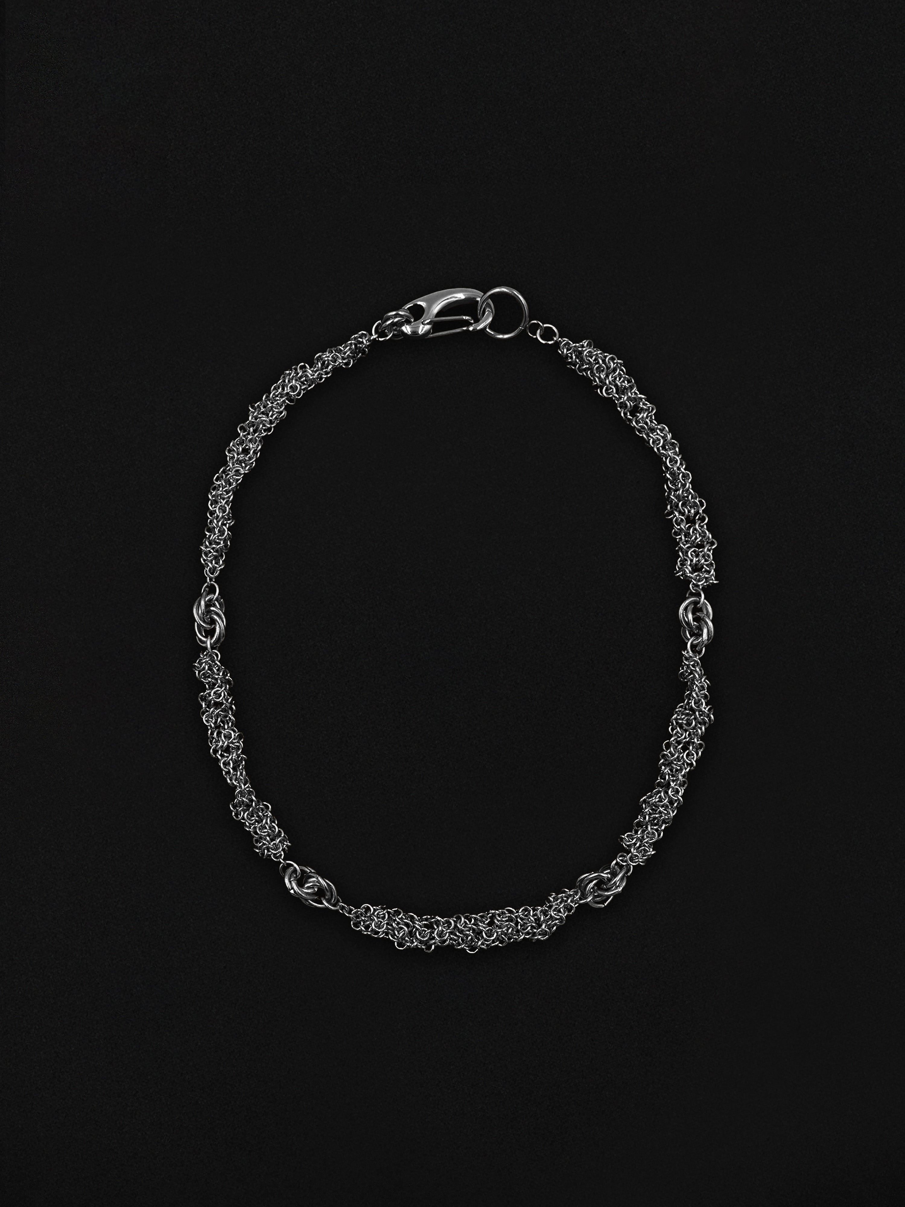 Silver chain necklace on a black background