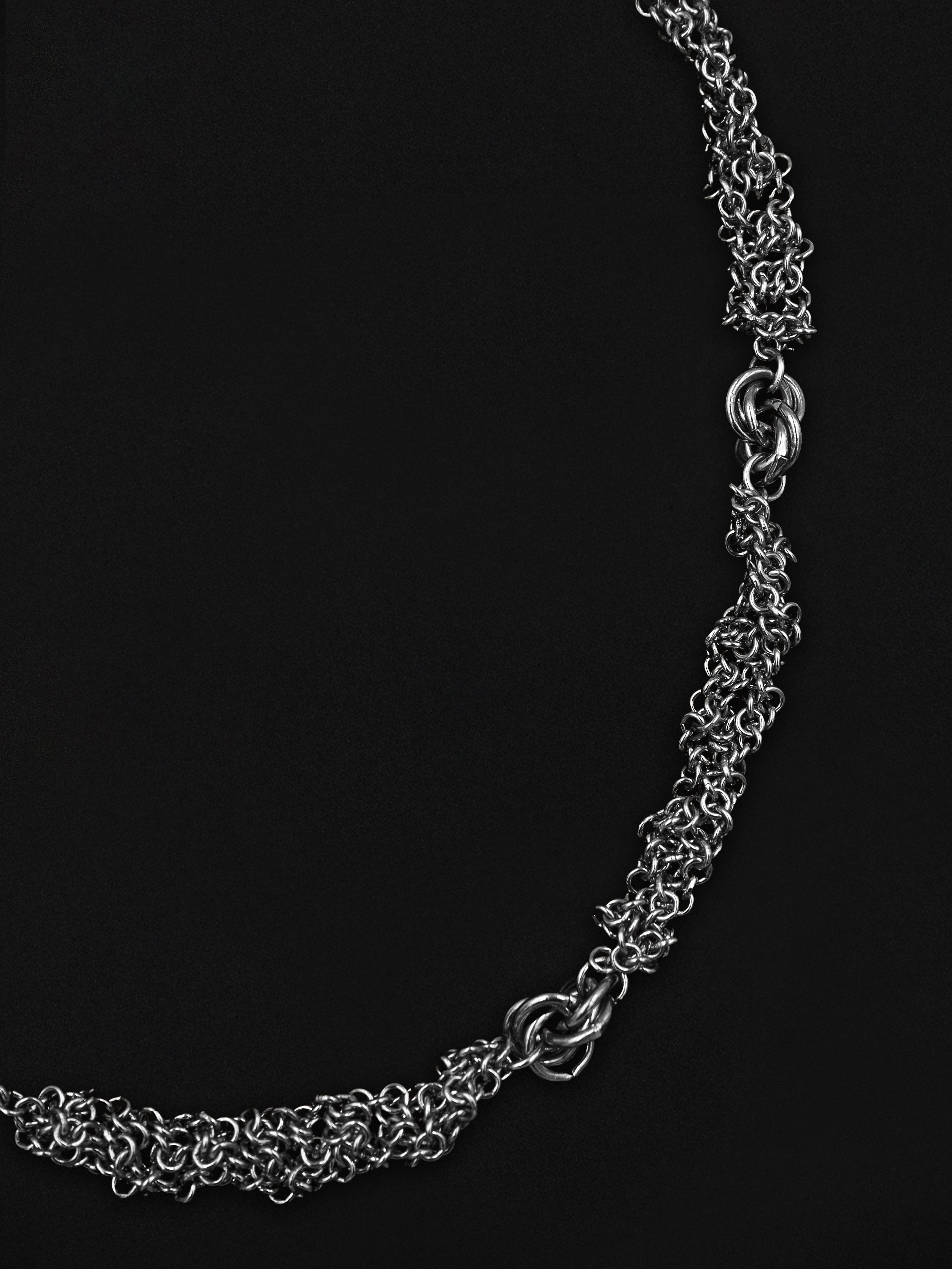 Silver chain necklace on a black background