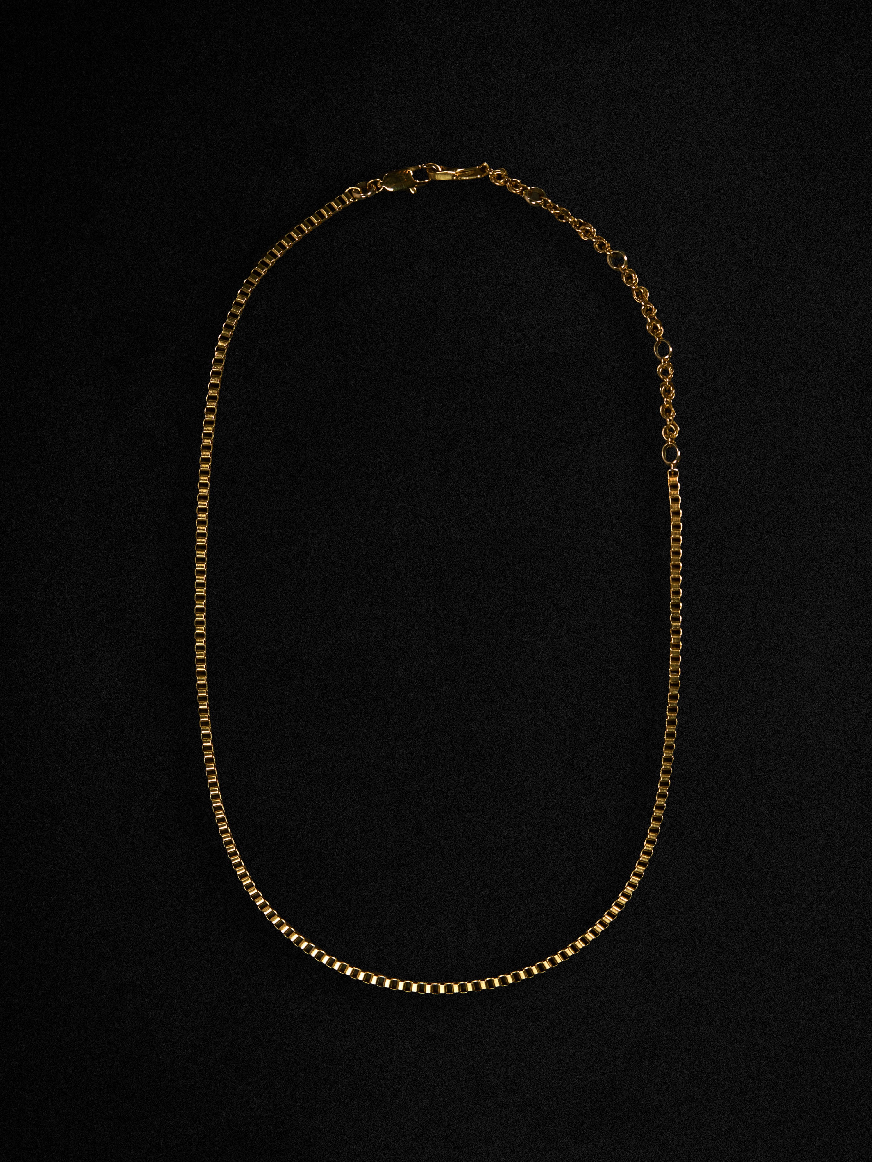 Gold chain necklace on a black background
