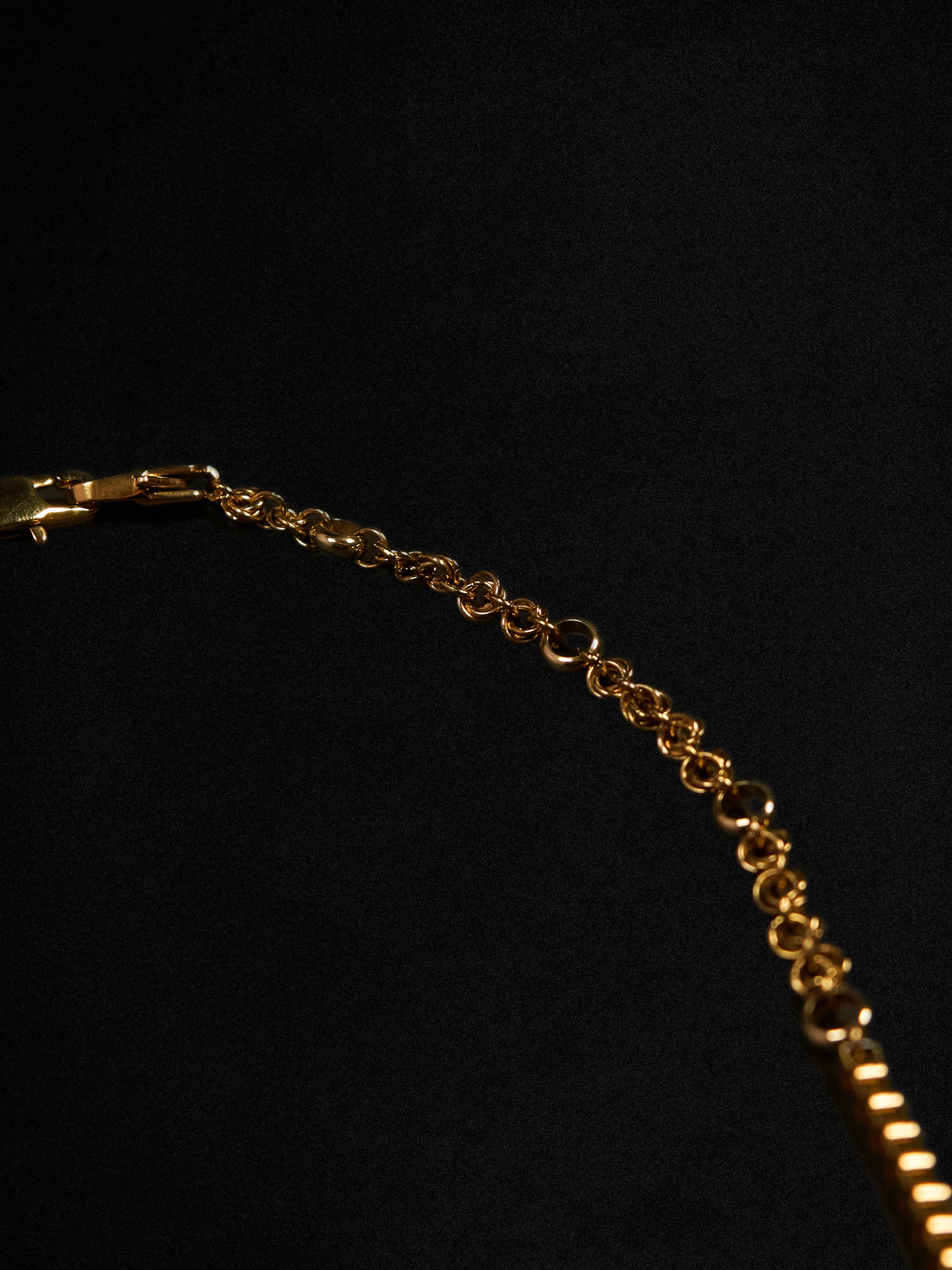 Gold chain necklace on a black background
