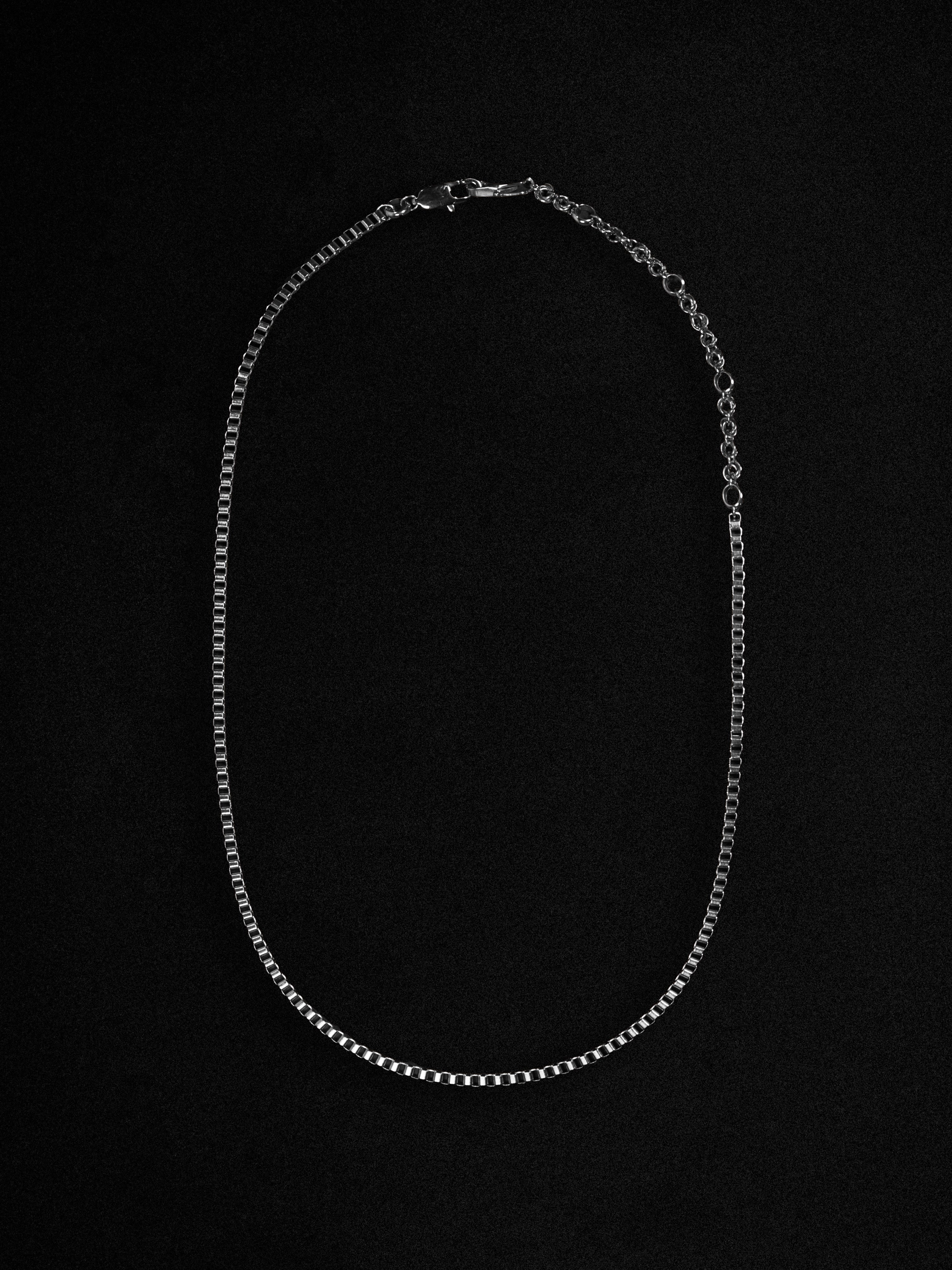 Silver chain necklace on a black background