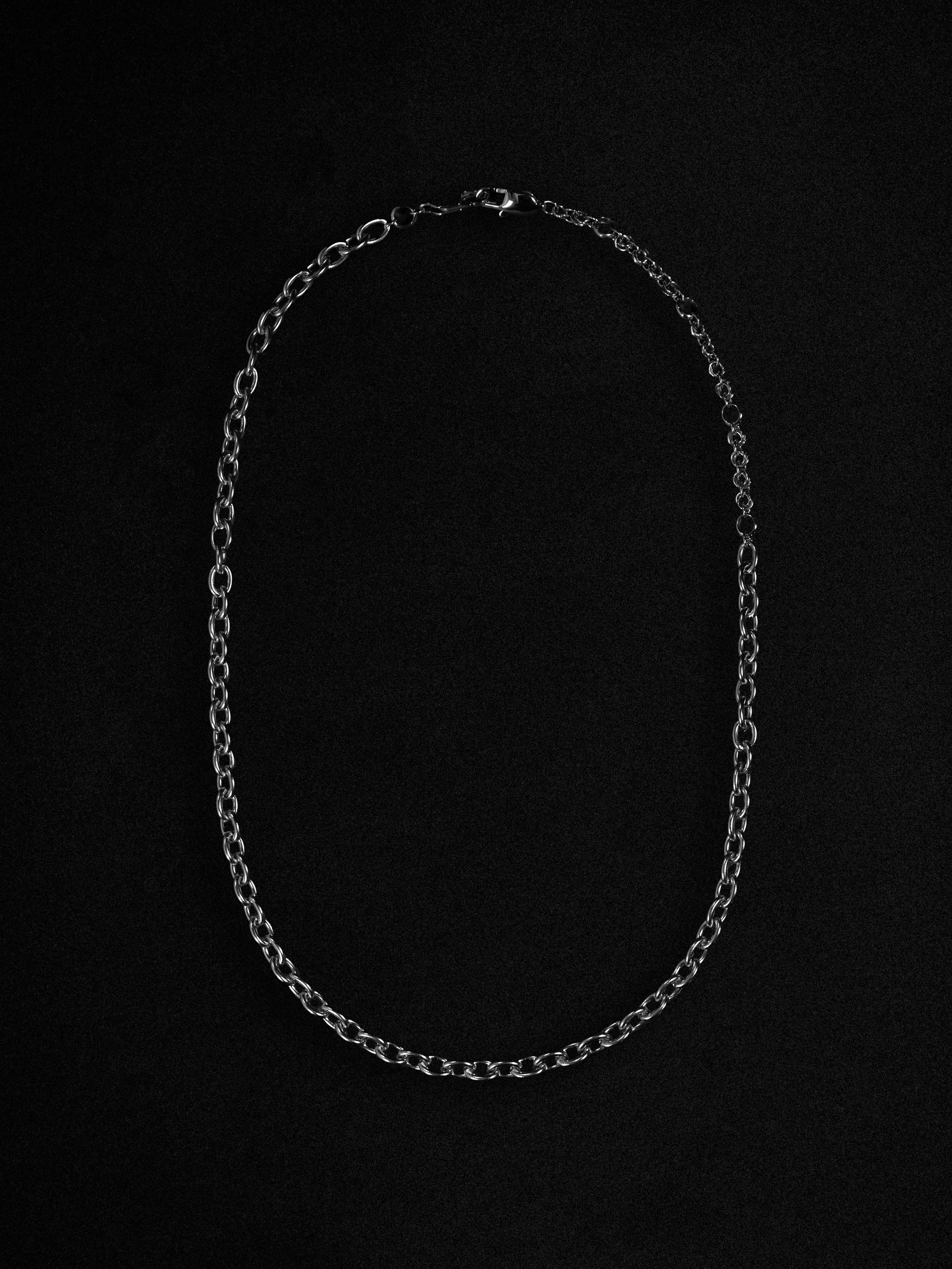 Silver chain necklace on a black background