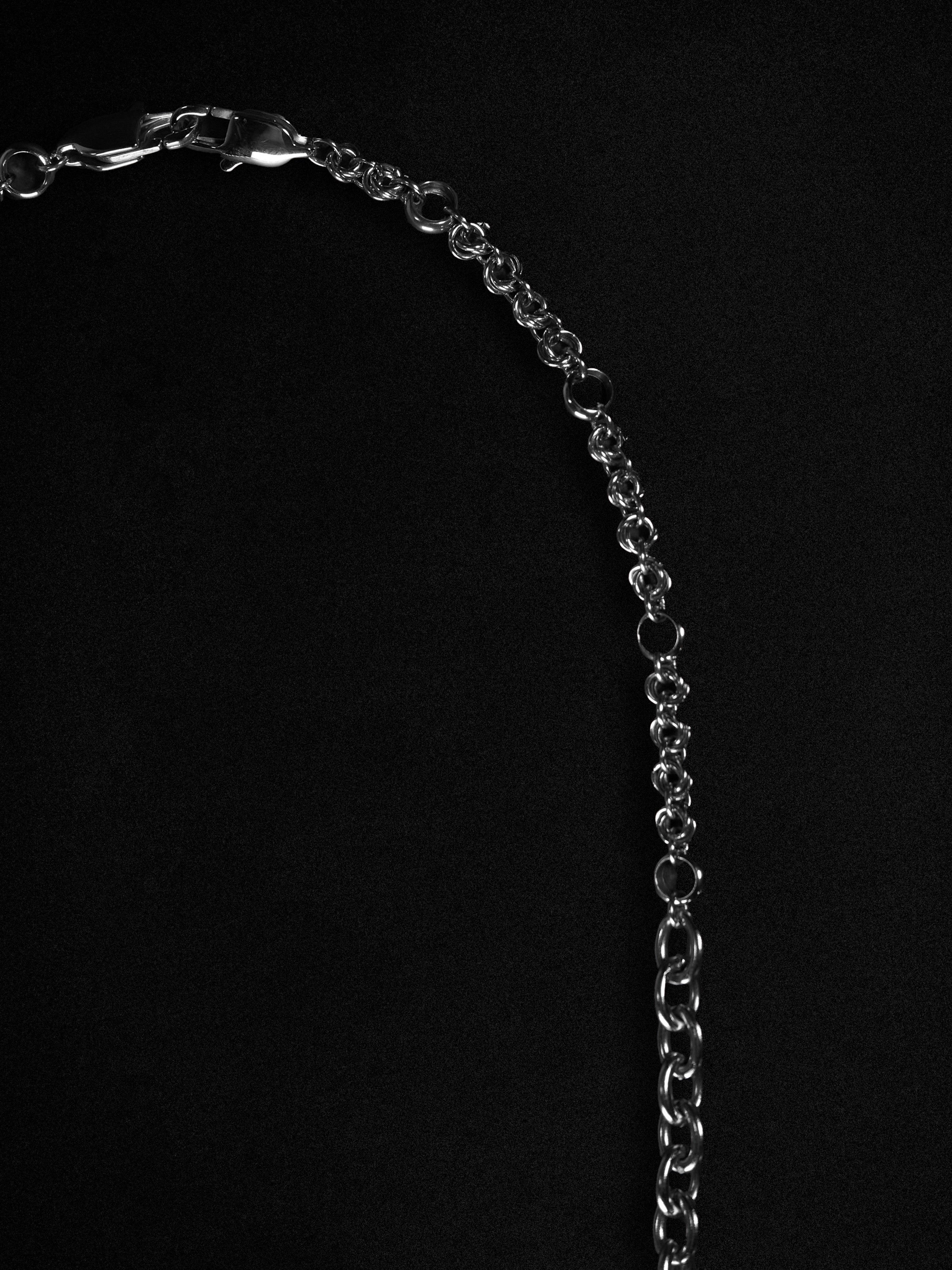 Silver chain necklace on a black background
