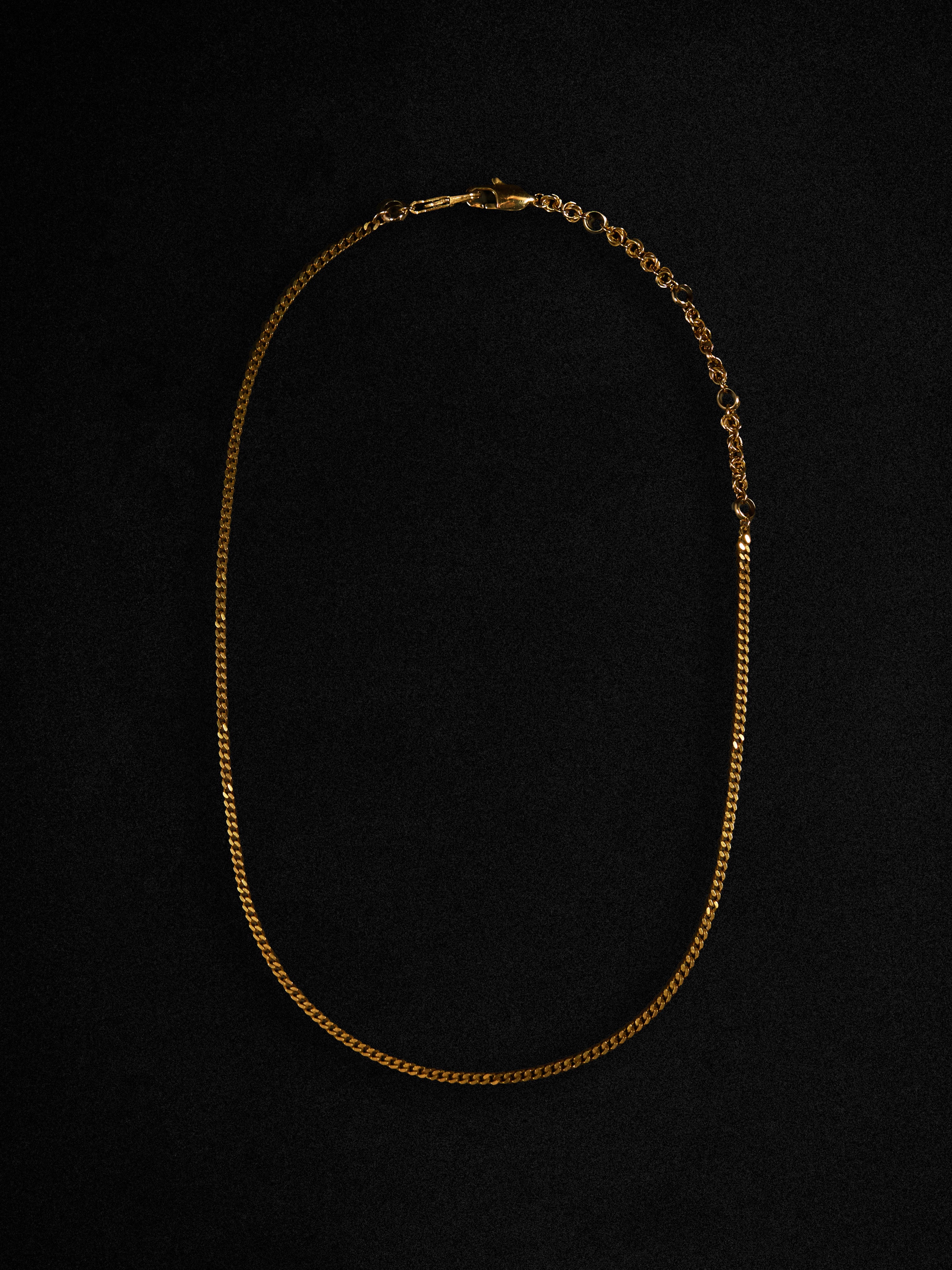 Gold chain necklace on a black background