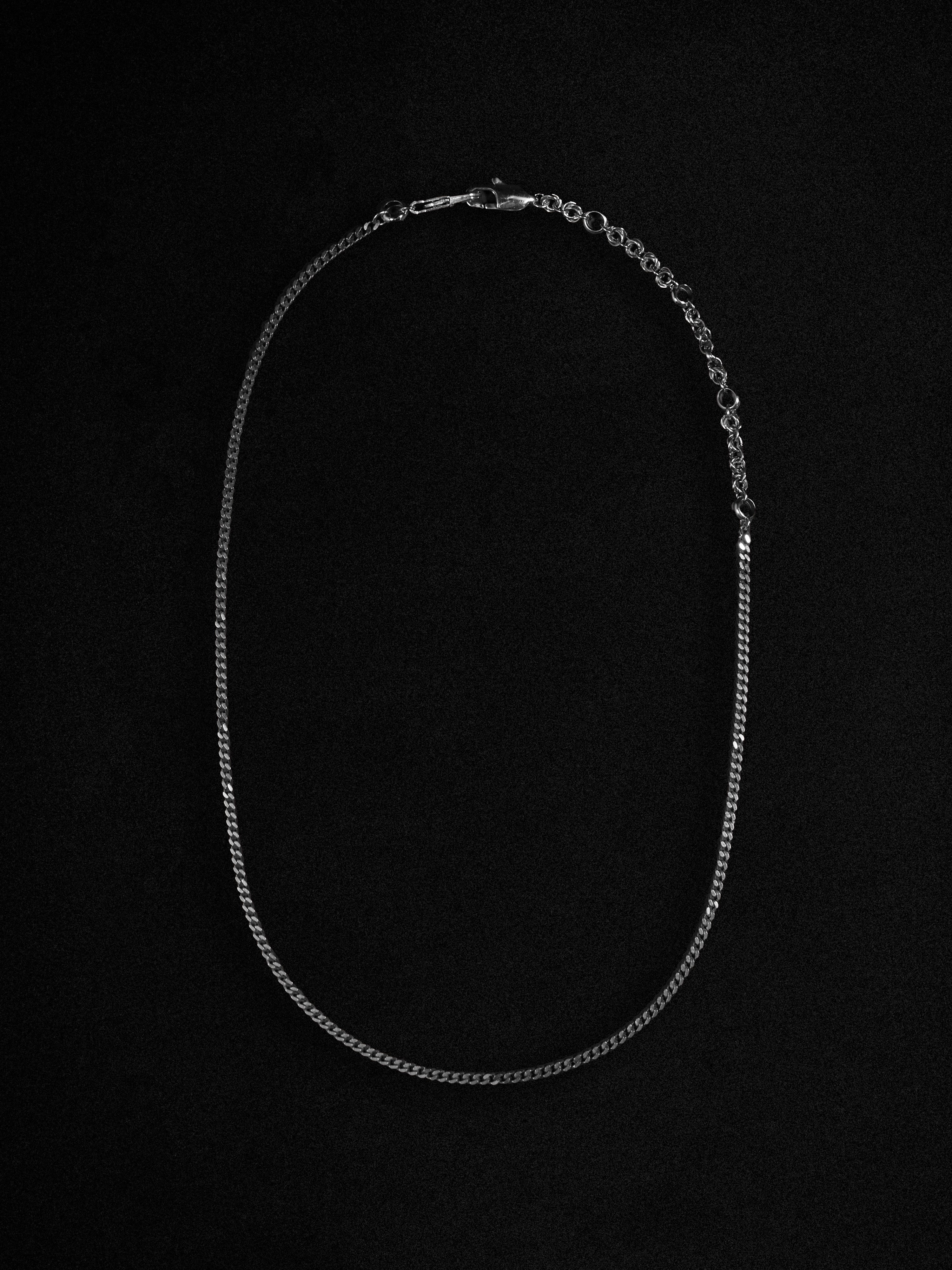 Silver chain necklace on a black background