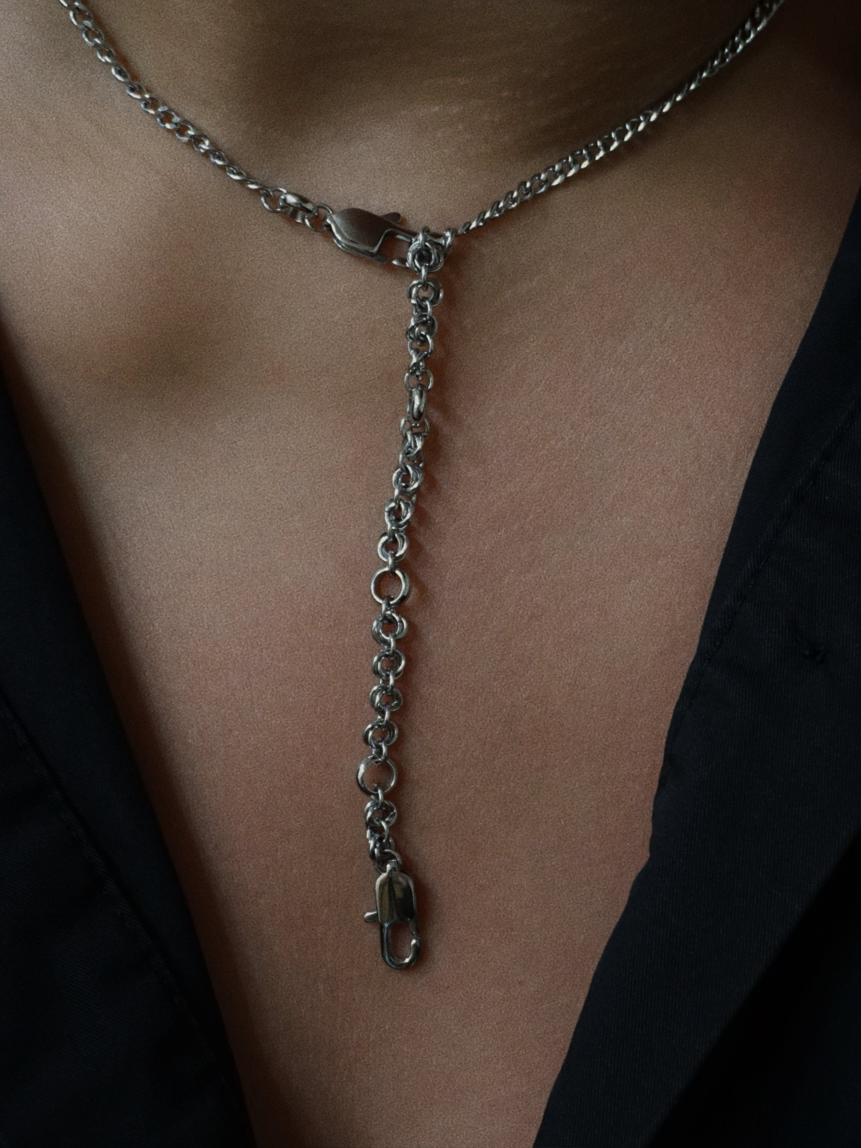 Silver chain necklace draped over a person's neck