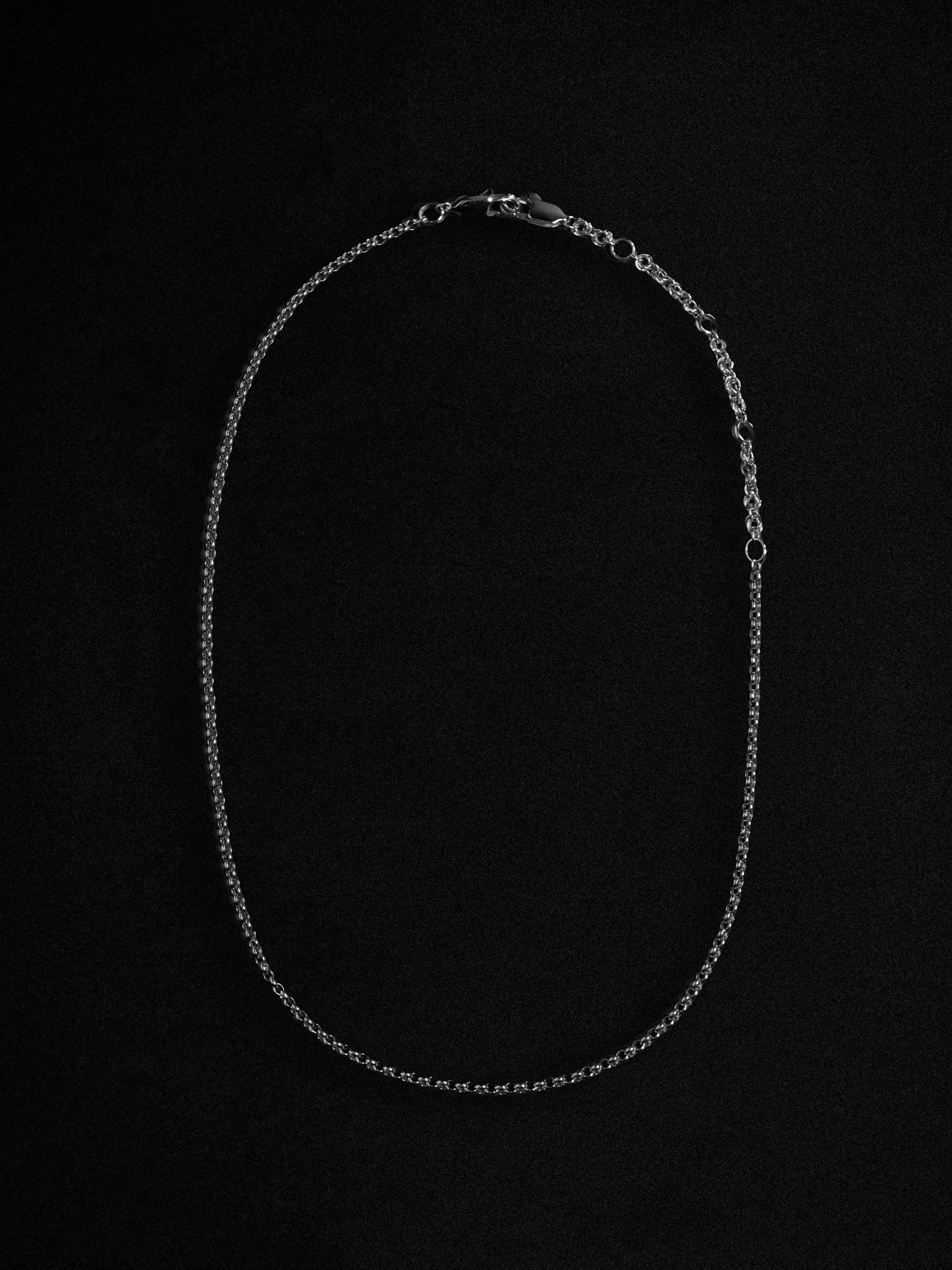 Silver chain necklace on a black background