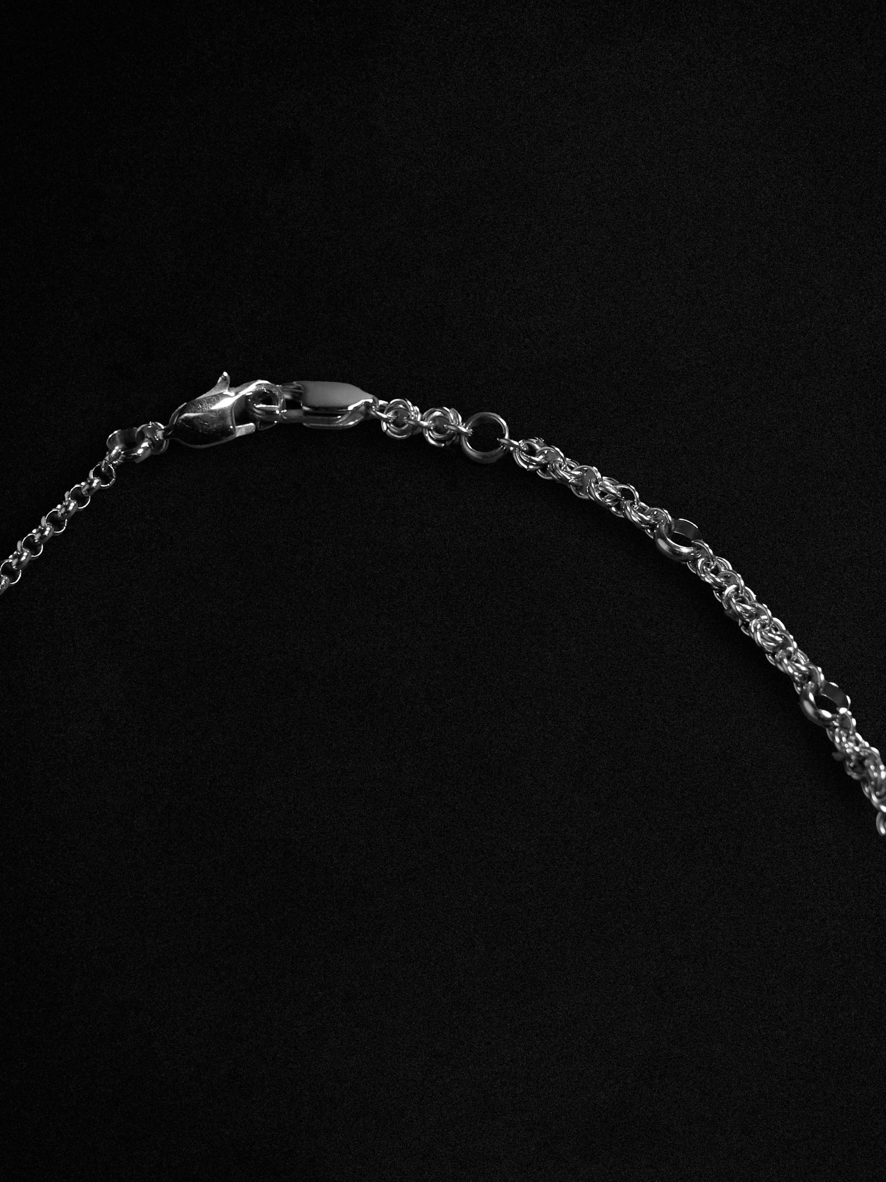 Silver chain necklace on a black background