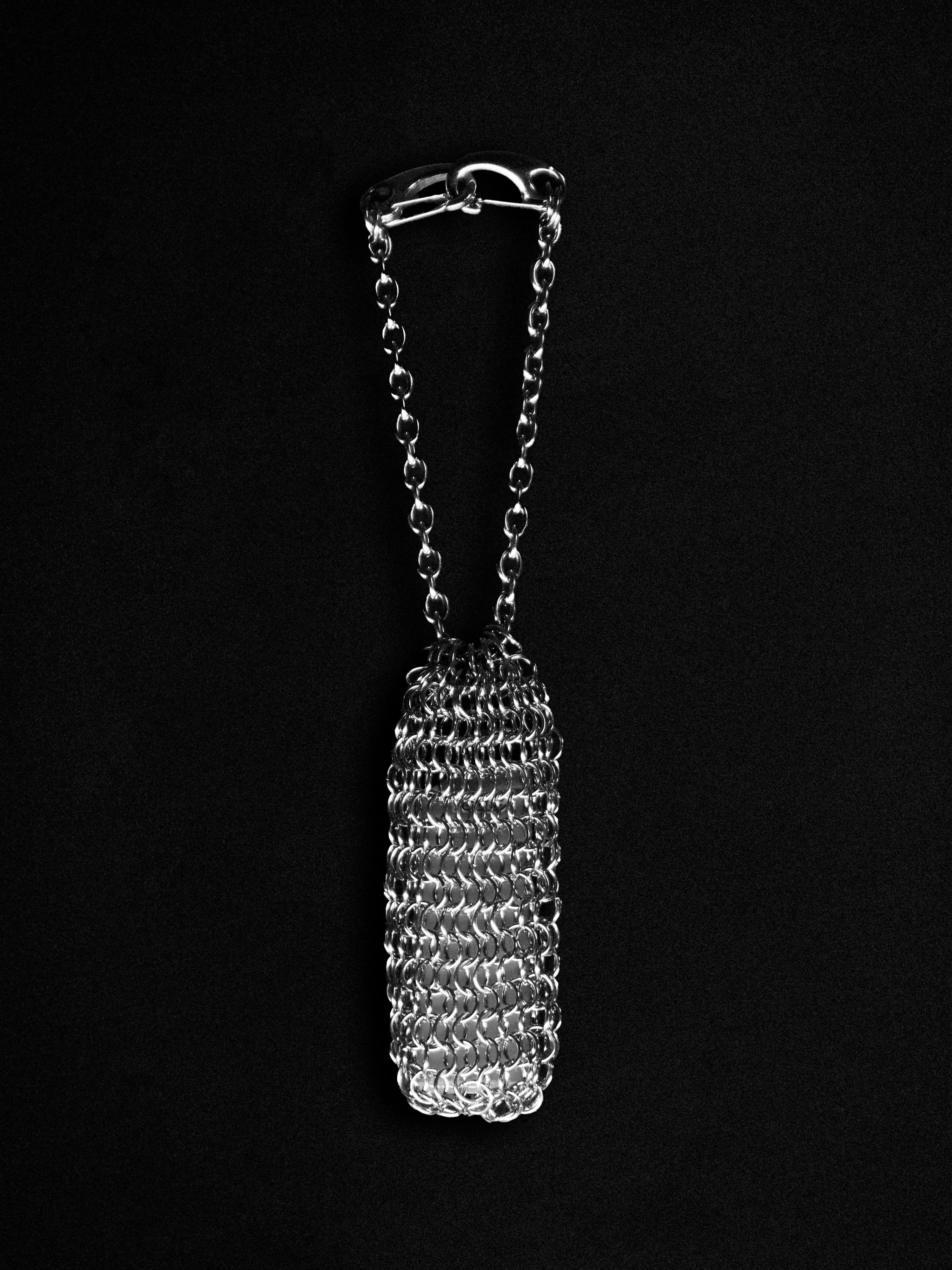 Metallic chainmaille pouch on a black background