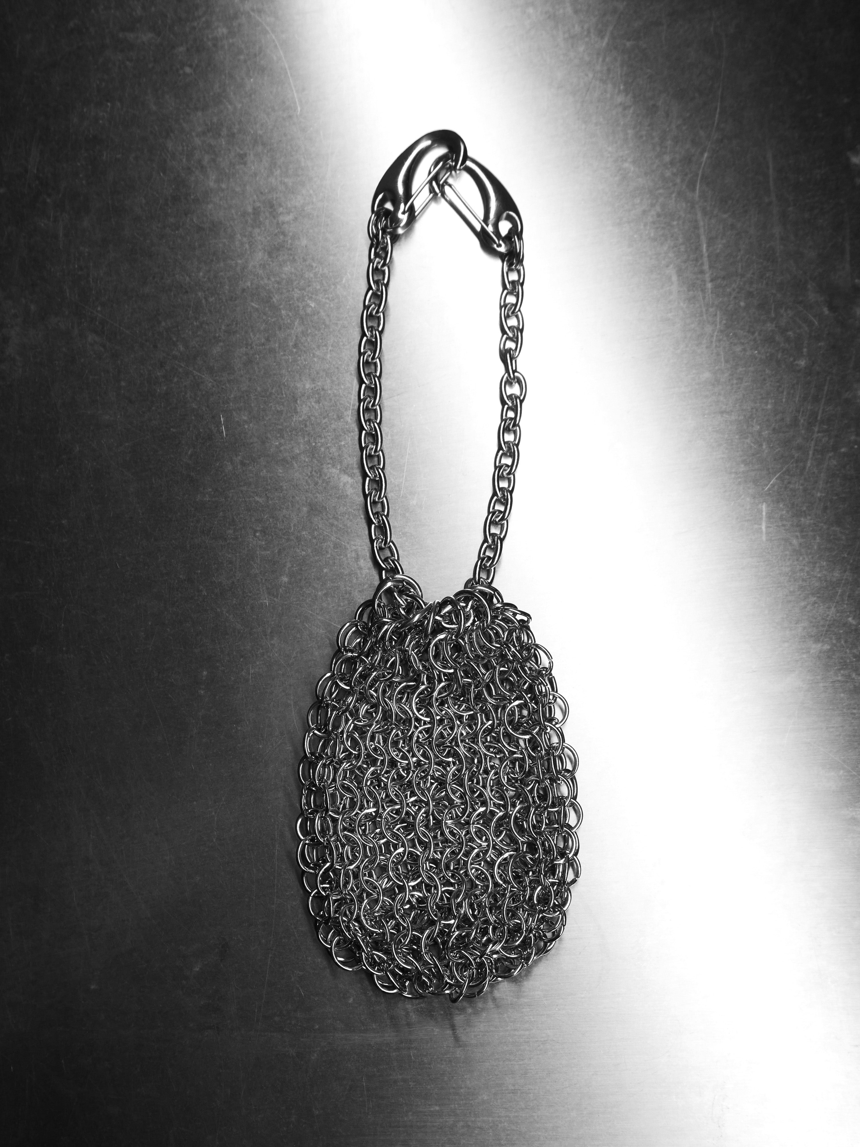 Metal chainmail pouch on a reflective surface