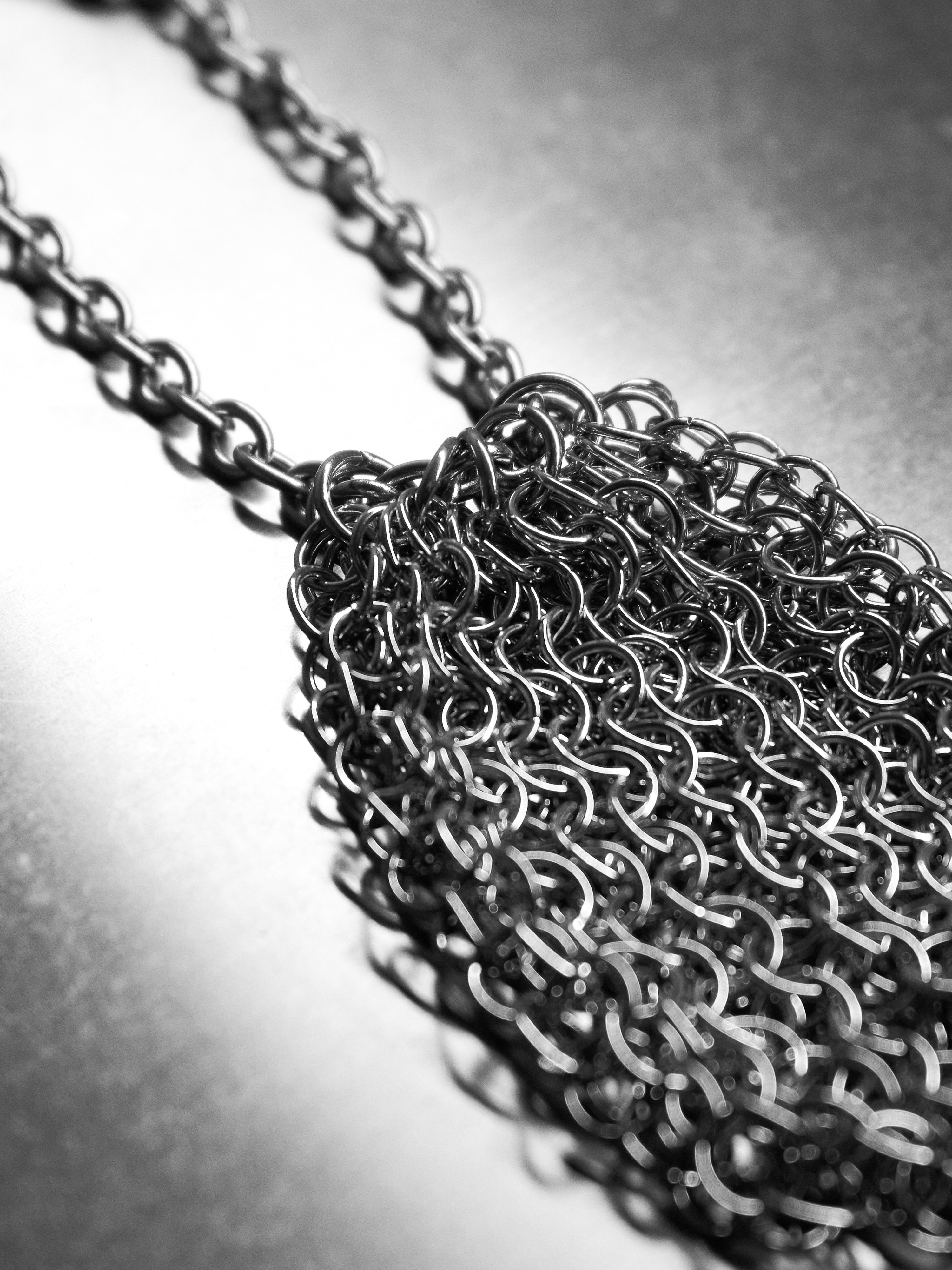 Close-up of a chainmaille pouch on a reflective surface